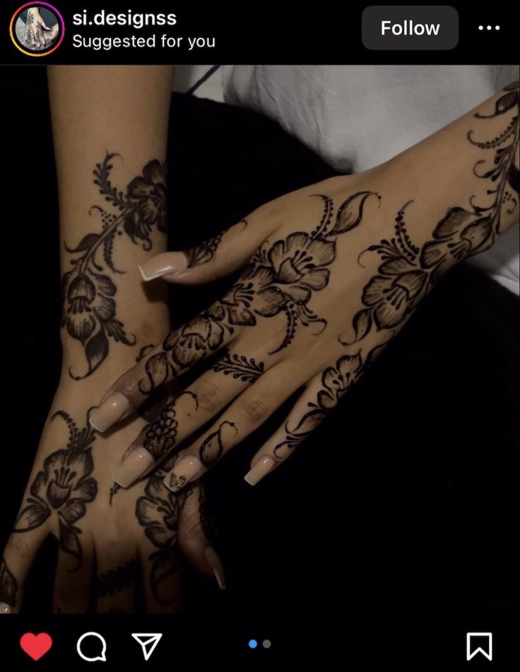 two hands with henna tattoos on them