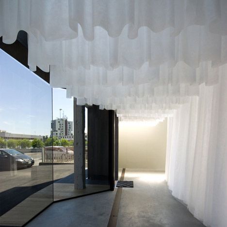 an empty room with curtains hanging from the ceiling and cars parked in the parking lot