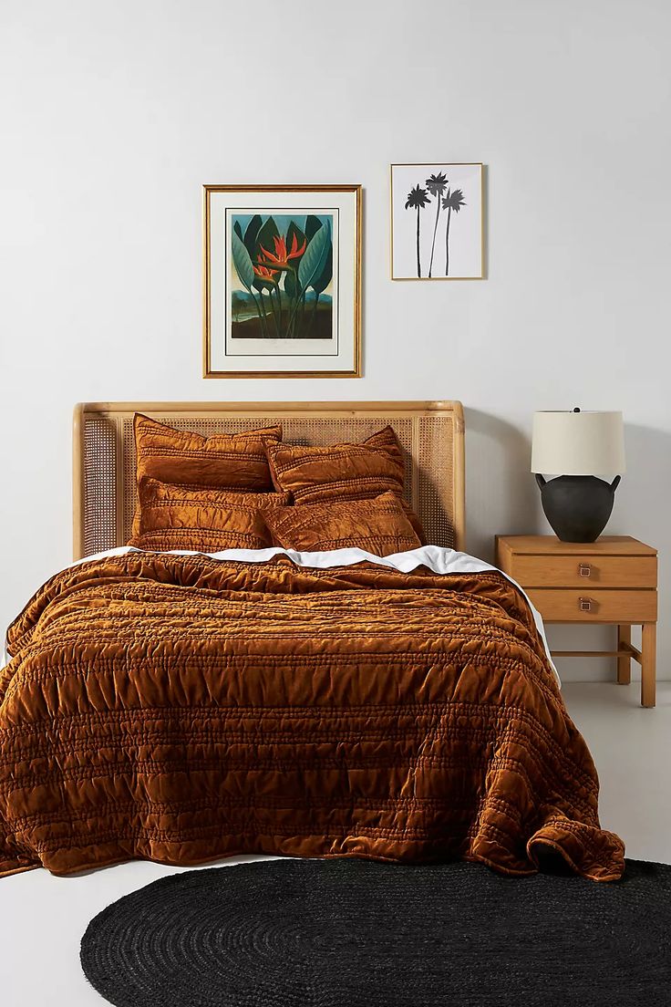 a bedroom with a bed, nightstands and pictures on the wall above it is shown