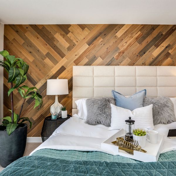 a bedroom with wood paneling on the wall and white bedding, along with two lamps