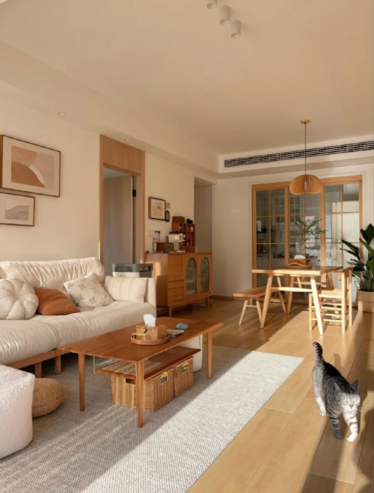 a living room filled with furniture and a cat standing in the middle of the room