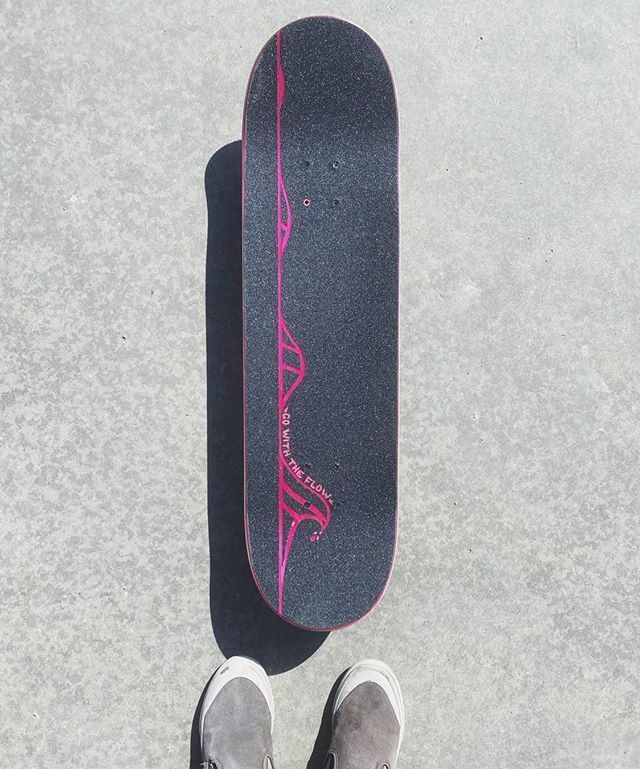 a person standing next to a skateboard on the ground with their feet in the air