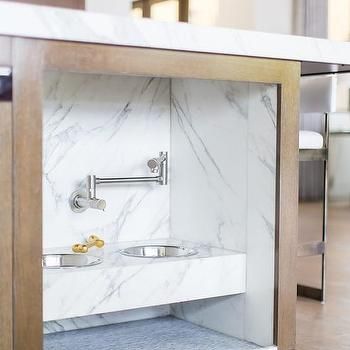 a white marble bathroom with stainless steel fixtures