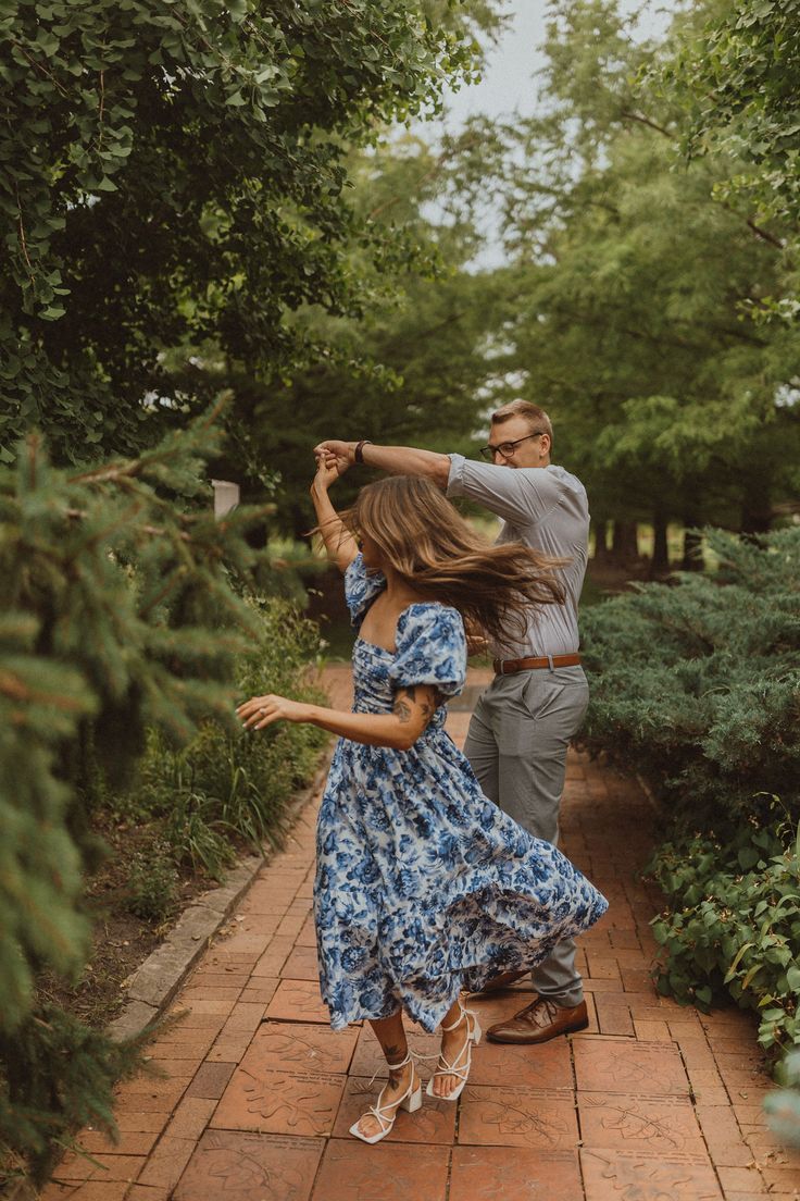 a man and woman dancing on a brick path