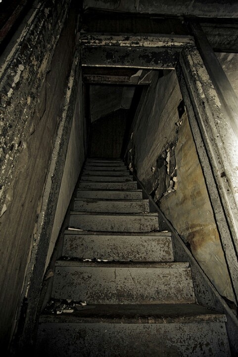 an old stairway leading up to the light at the end of the stairs is dirty