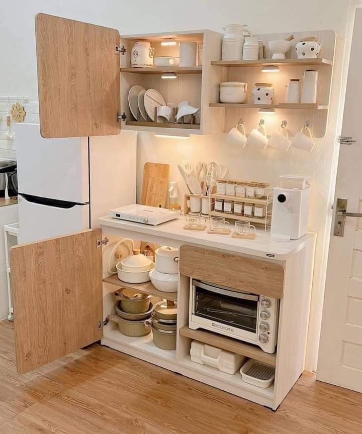 a small kitchen with wooden cabinets and white dishes on the shelves, including an oven