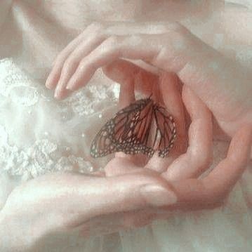 a woman holding a butterfly in her hands