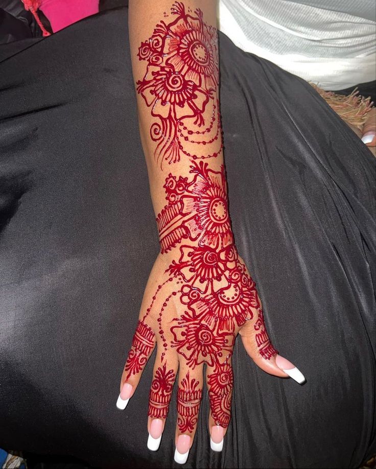 a woman's hand with henna tattoos on it