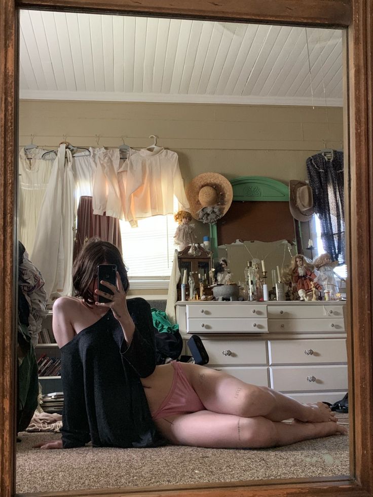 a woman laying on the floor in front of a mirror