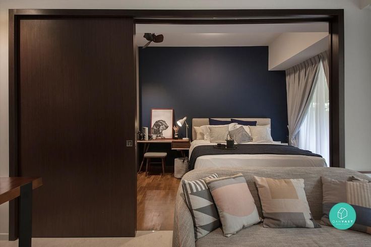 a bed sitting next to a wooden door in a bedroom