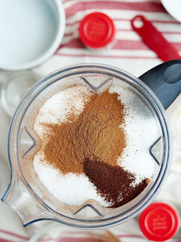 a blender filled with spices on top of a red and white striped table cloth