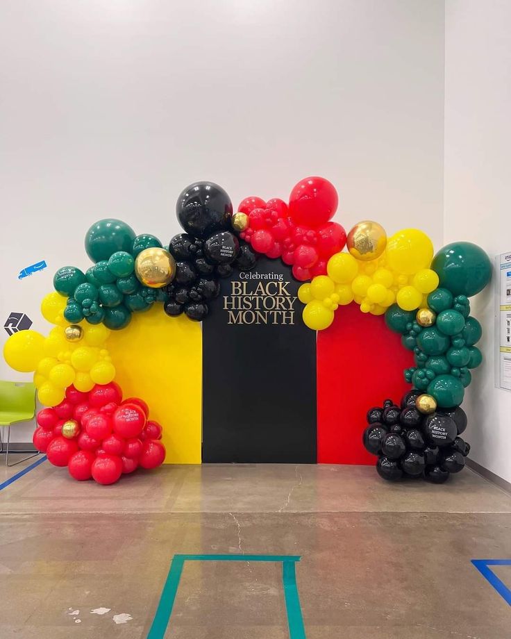 balloon arch with black history month sign and red, yellow, green, and blue balloons