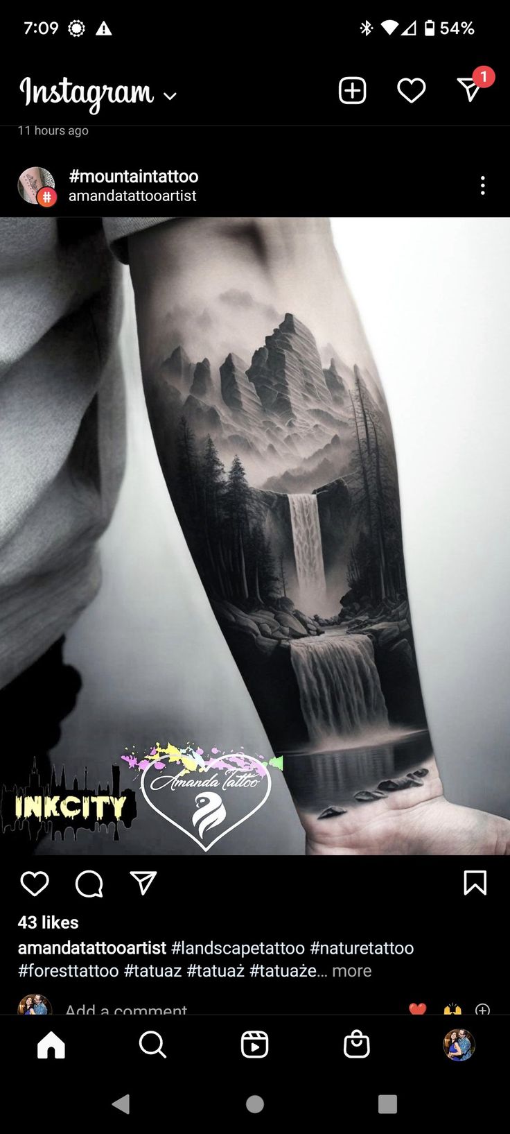 a man's arm with a waterfall and mountains on it