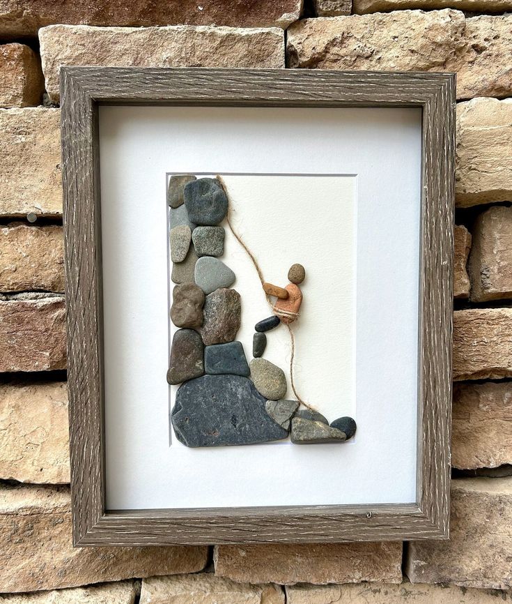 a rock and stone artwork in a wooden frame