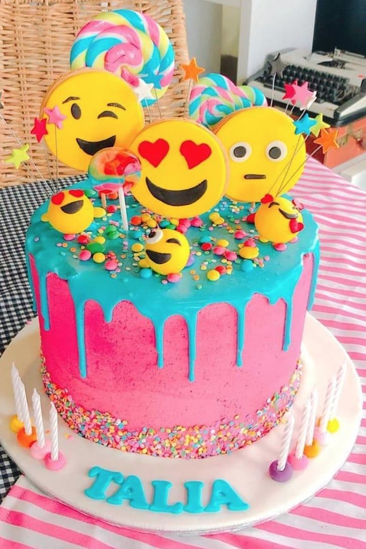 a birthday cake decorated with smiley faces and sprinkles is on a table