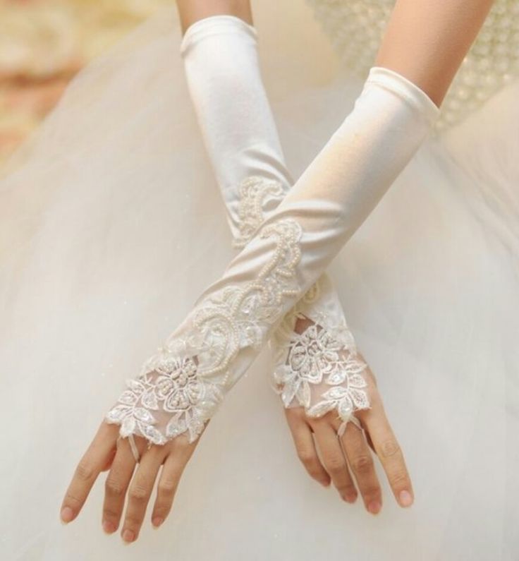 the bride is wearing white gloves with lace