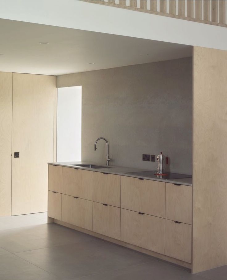 an empty kitchen with wooden cabinets and stainless steel sink faucet in the center