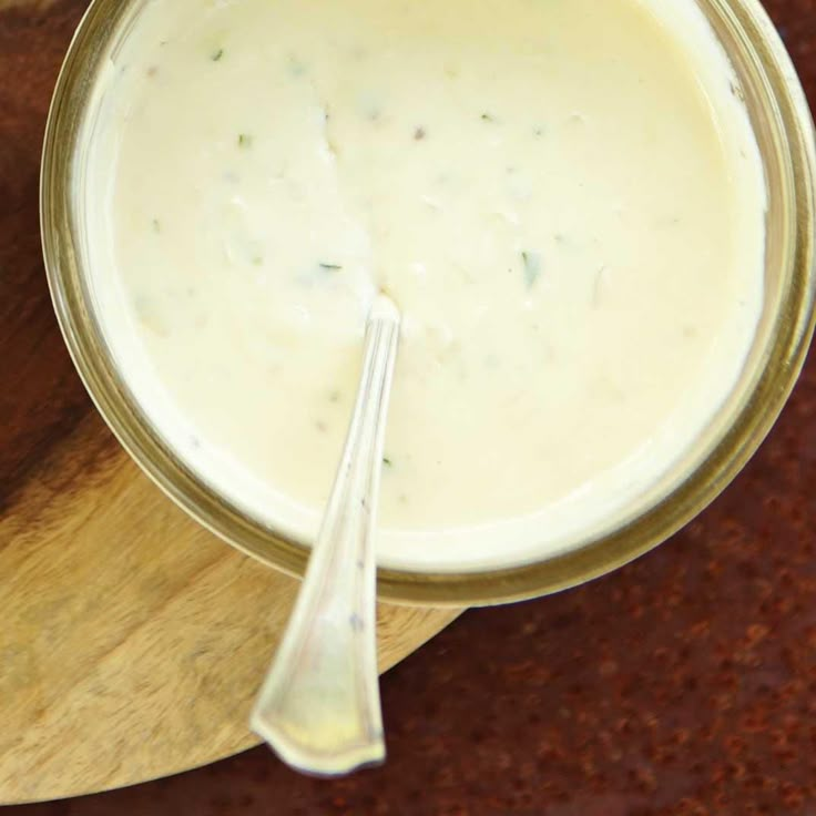 a wooden spoon sitting next to a jar filled with cream