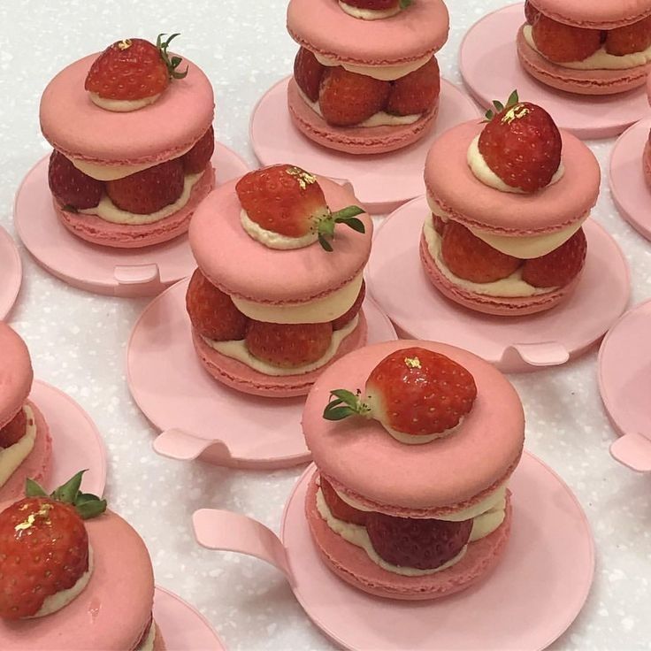 there are many pink desserts with strawberries on them