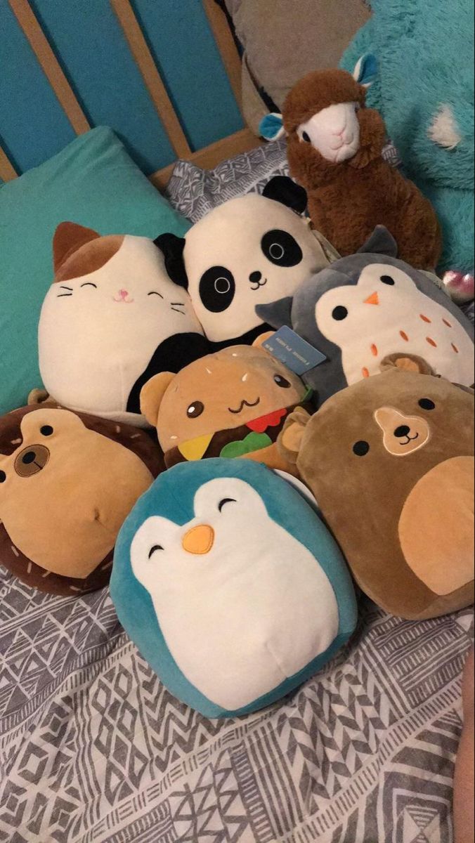 several stuffed animals laying on top of a bed