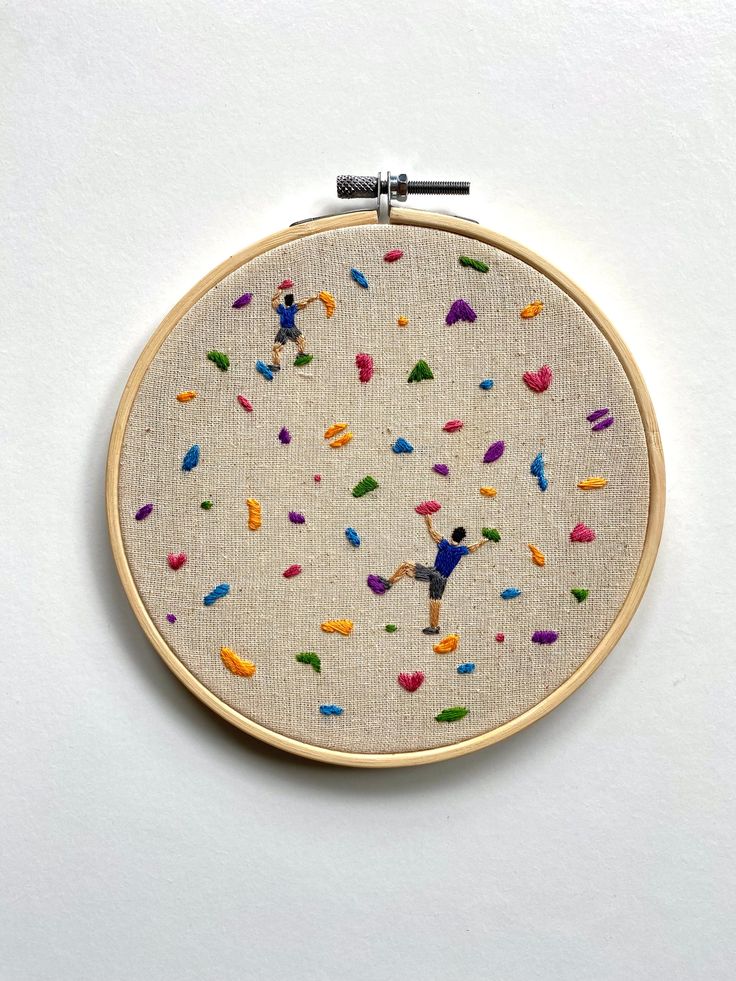 an embroidery hoop with colorful sprinkles on it, hanging from the wall