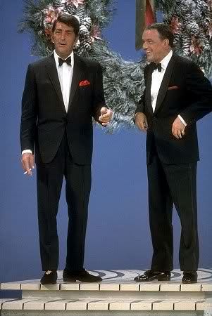 two men in tuxedos standing on stage