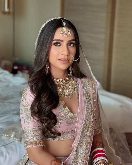 a woman in a bridal outfit sitting on a bed