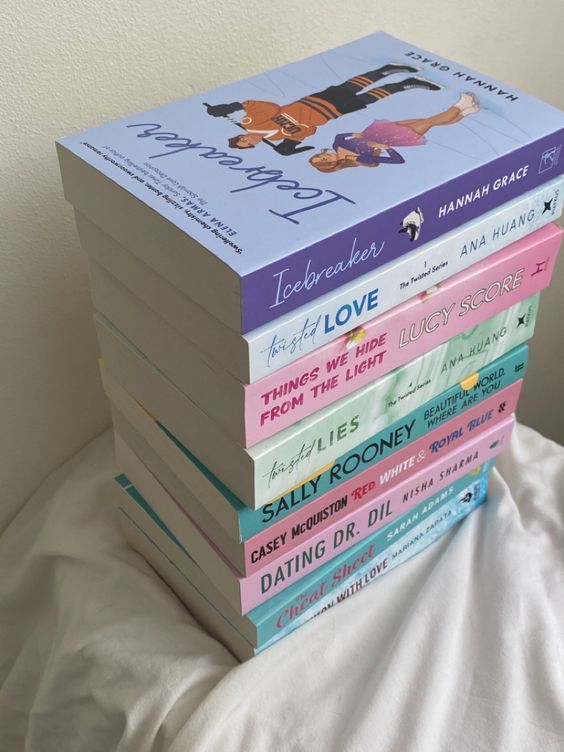 a stack of books sitting on top of a bed