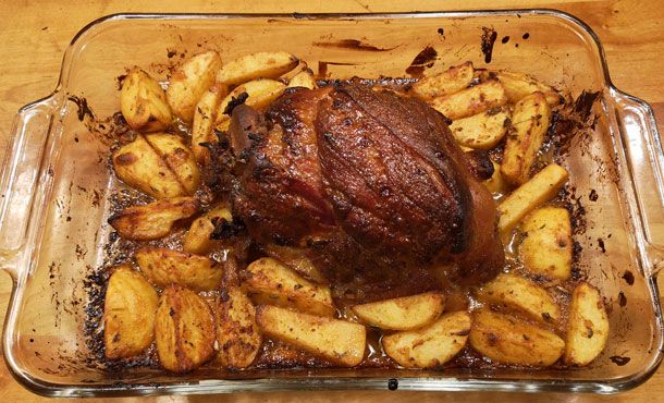 a roasting pan filled with potatoes and meat