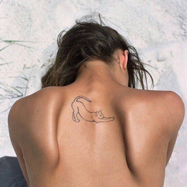 a woman with a cat tattoo on her back