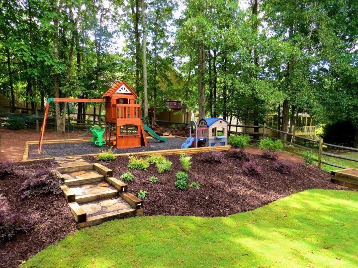 a playground in the middle of a wooded area with steps leading up to it and a slide