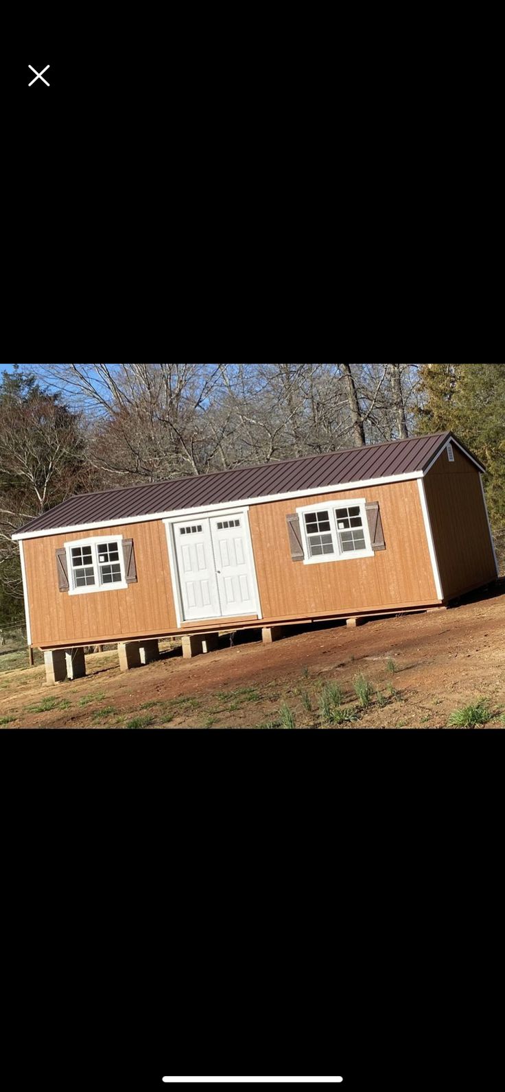 a small building with two windows on the side