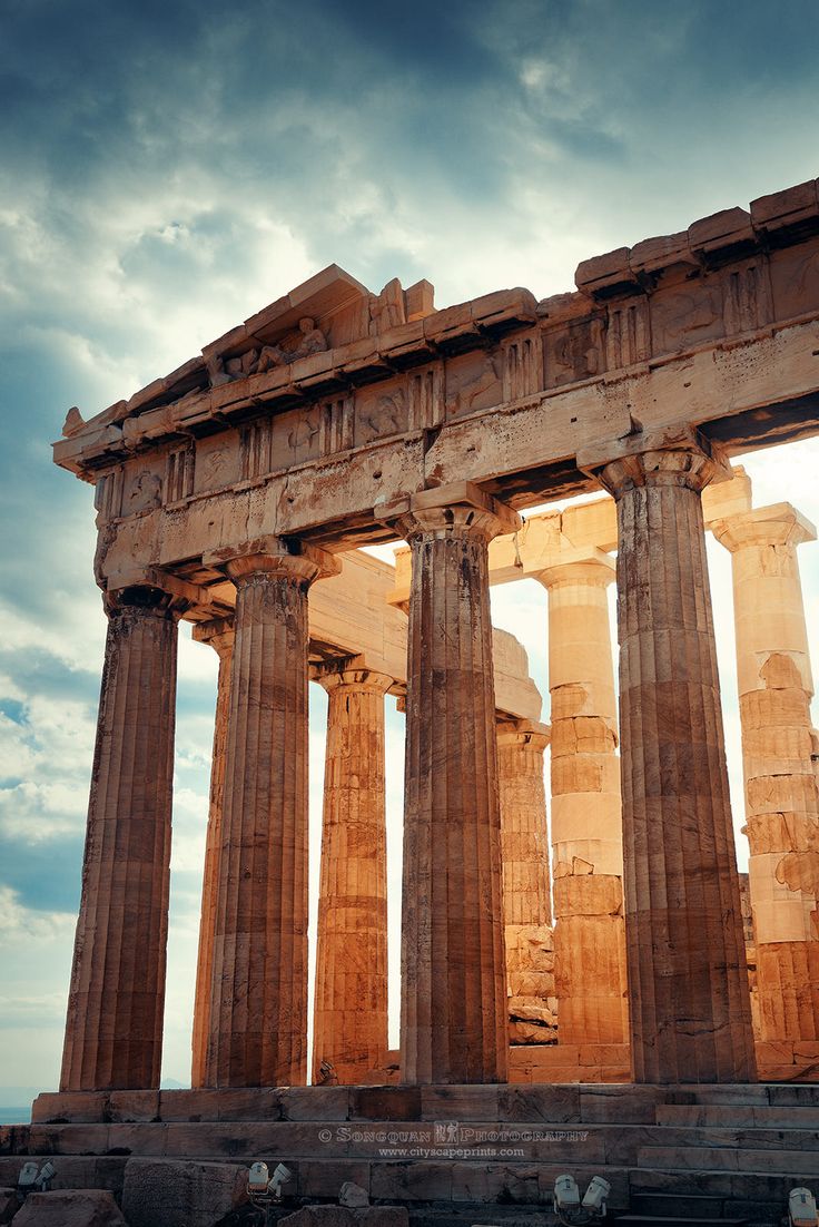 the ruins of an ancient greek temple against a cloudy sky