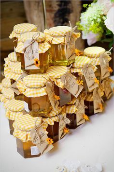 several honey jars are stacked on top of each other with tags attached to the lids