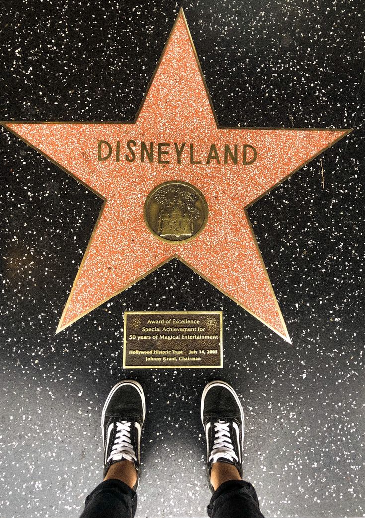 a person standing in front of a star on the hollywood walk of fame with their feet up