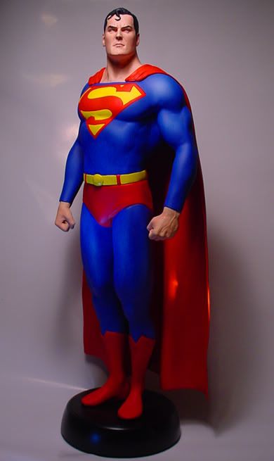 a statue of superman standing on top of a black base