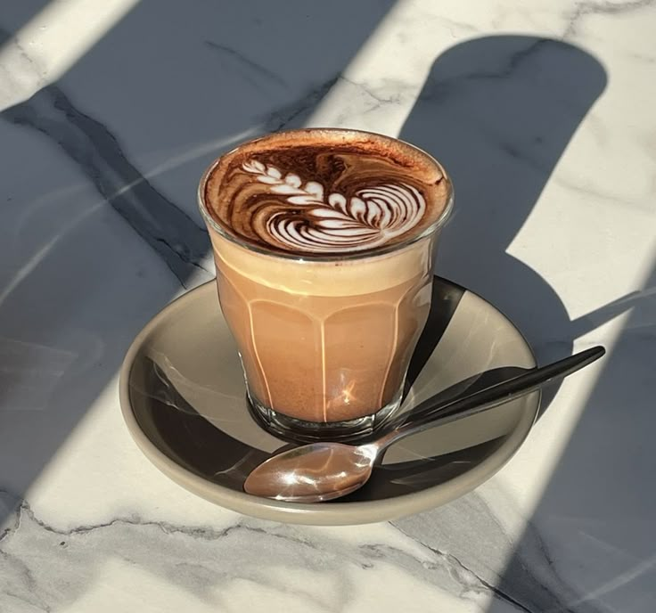 a cappuccino on a saucer with spoons