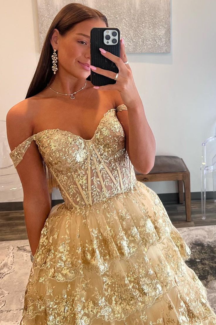 Make an unforgettable entrance in this eye-catching off-the-shoulder gold-sequin ruffle multi-layer long gown. Featuring exquisite gold-sequin lace, a deftly crafted lace-up back, and multiple layers of tulle for a luxurious effect, this showstopping dress is the perfect choice for any special occasion. Be the belle of the ball!

SKU: MD0575
Tulle Fabric
Floor Length
Size: US 0-26 W. Check our Size Chart to get your correct size. 
Recommend custom size for plus size.
Free custom size service is available. Email your exact measurements once order is placed. 
Fully lined & Built with bra
Processing time: 10-15 business days. 
If you want to speed up your dress processing time, please put in the link of rush order fee into your shopping cart to check out with the item you want. And email us t One Shoulder Homecoming Dress, Gold Prom Dress, Sequin Ball Gown, Tiered Tulle Skirt, Gold Prom, Elegant Ball Gowns, Sequin Prom Dress, Evening Party Gowns, Lace Prom Dress