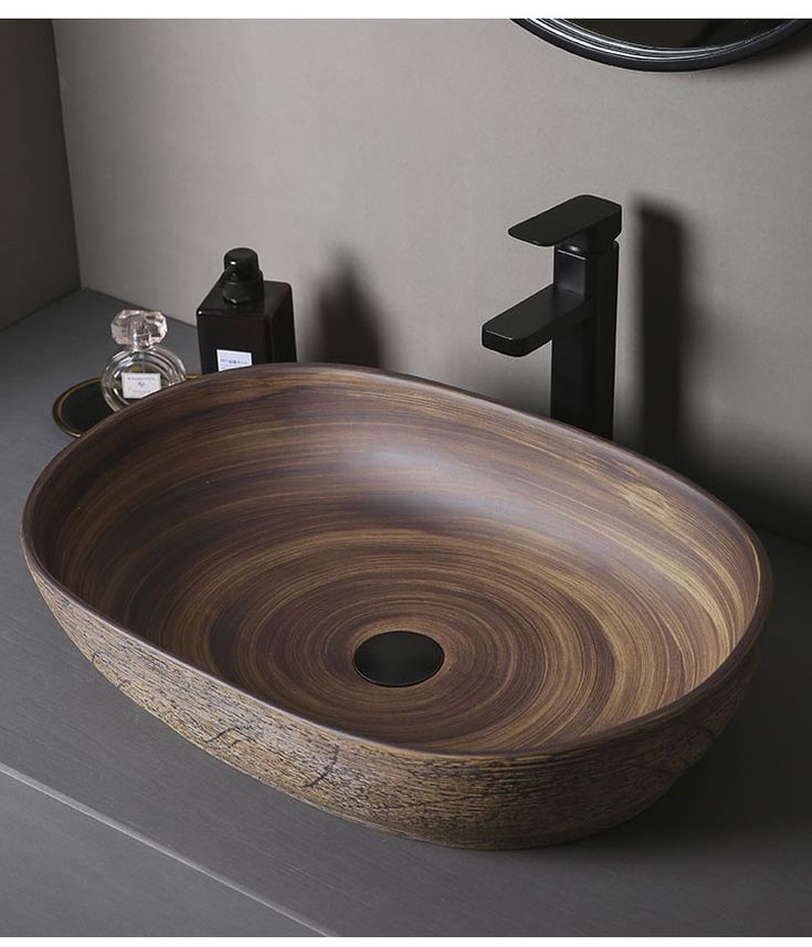 a wooden bowl sink sitting on top of a counter next to a faucet