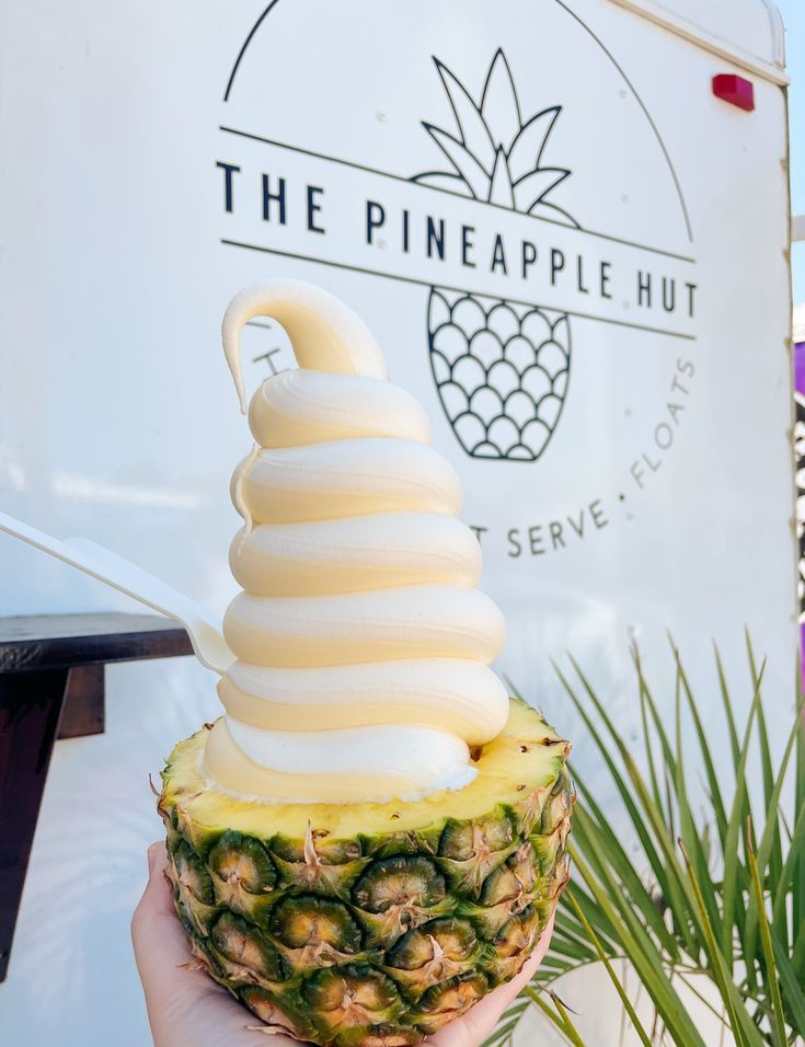 a person holding a pineapple shaped ice cream cone