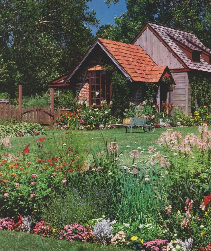 a garden with flowers and a house in the background