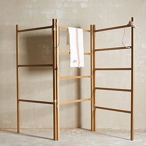 a wooden ladder leaning against a wall next to a towel rack