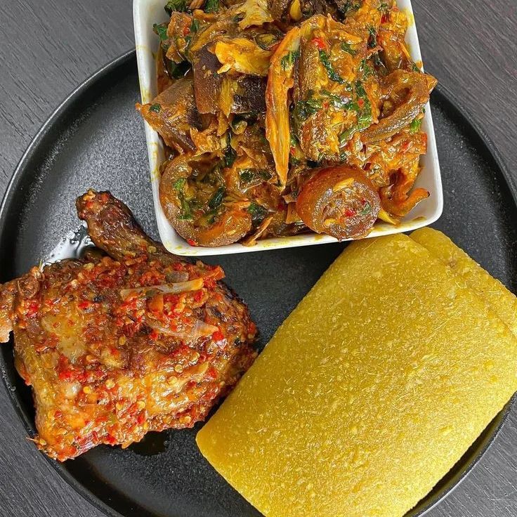 a black plate topped with different types of food next to a yellow dish on top of a wooden table