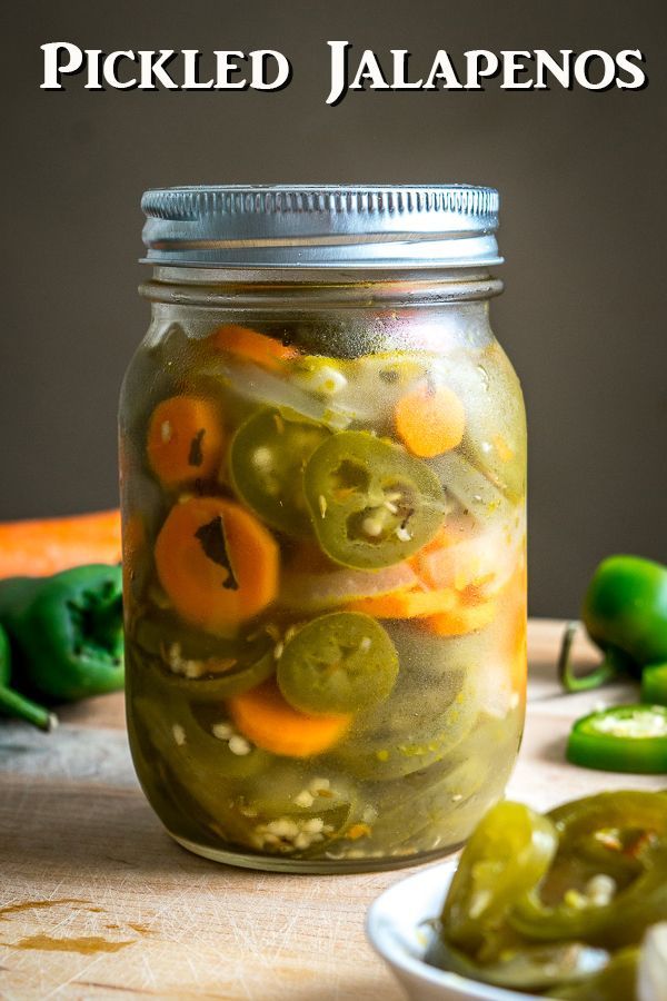 pickles and peppers in a jar on a table