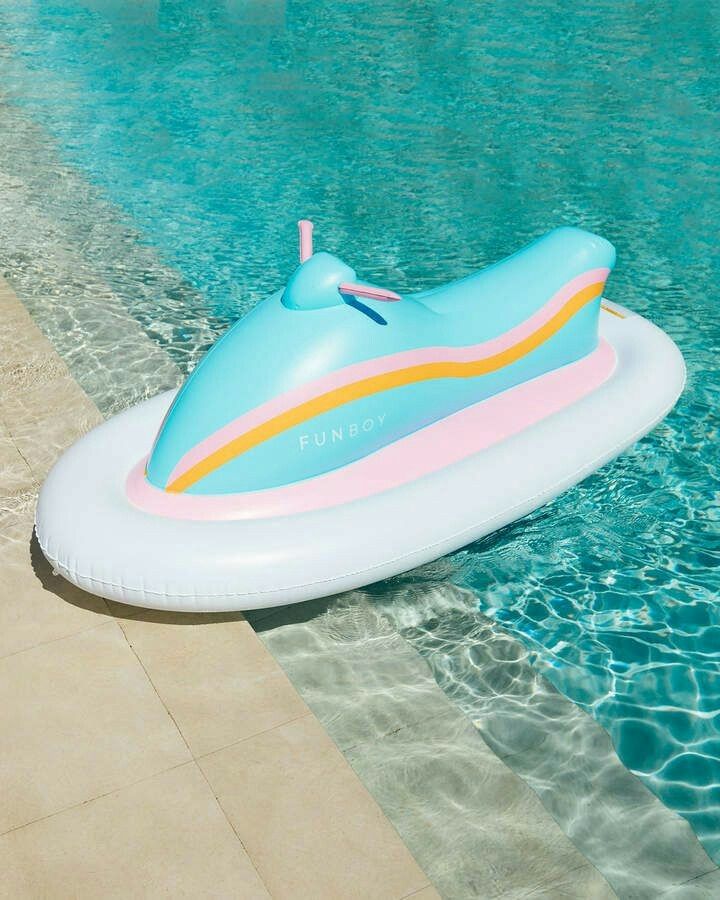 an inflatable boat sitting on the edge of a swimming pool