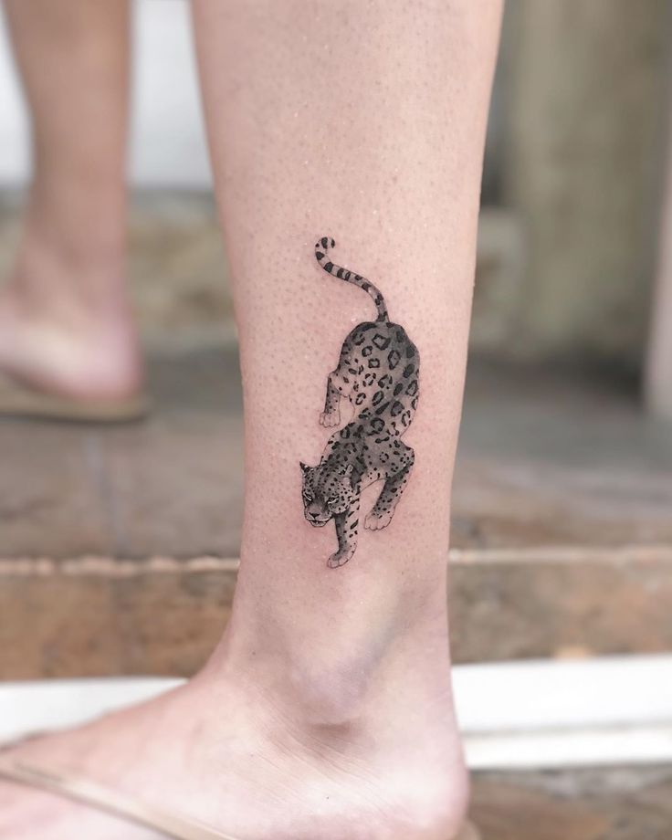 a small tattoo on the foot of a woman's leg, depicting a cheetah