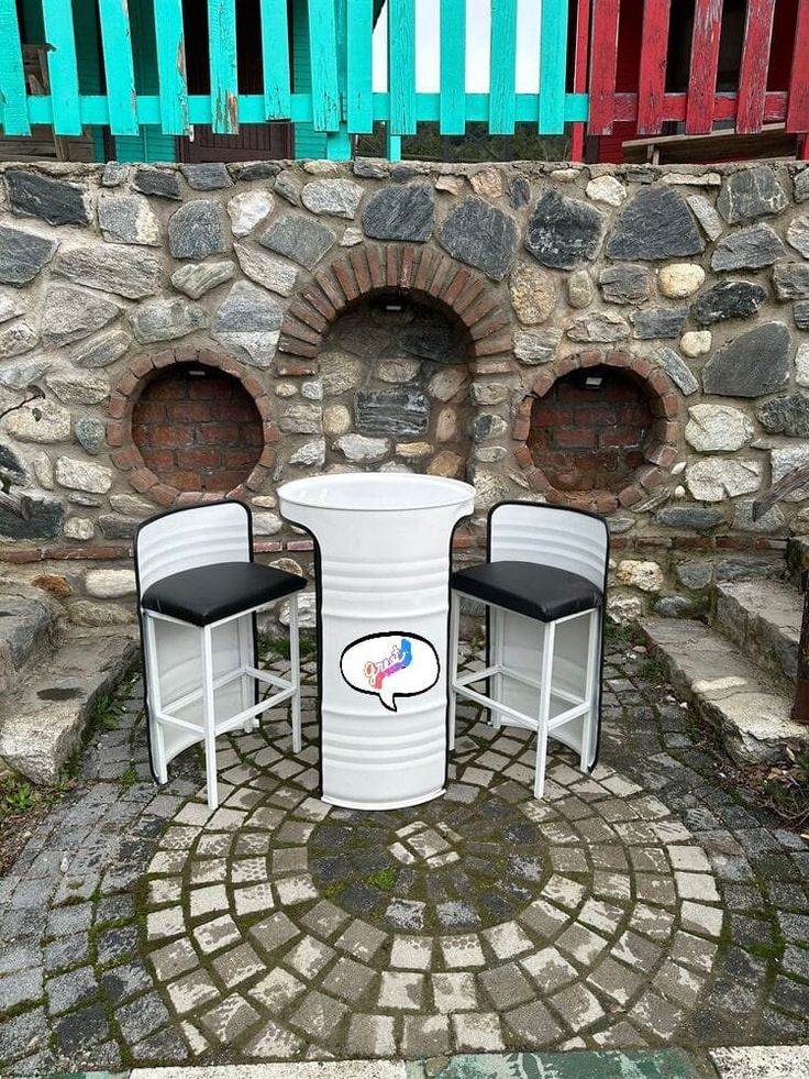 two chairs and a table in front of a brick wall