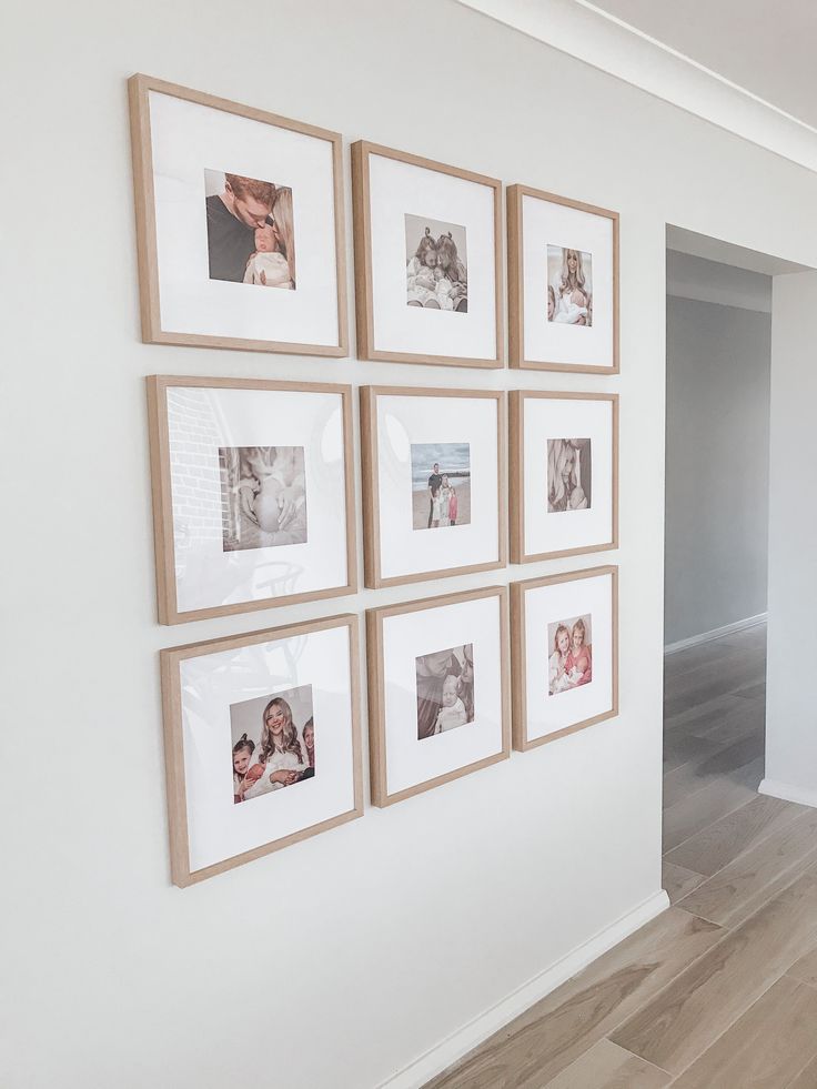 a white wall with many pictures hanging on it's sides and wood flooring