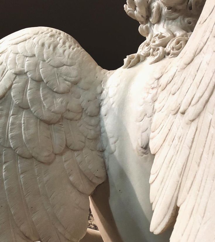 a statue of an angel riding a horse with wings on it's back side