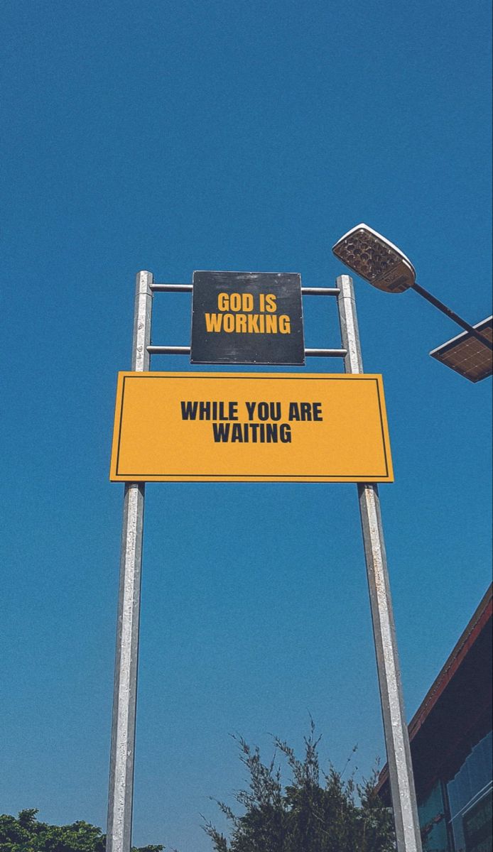 a yellow sign that says god is working while you are waiting